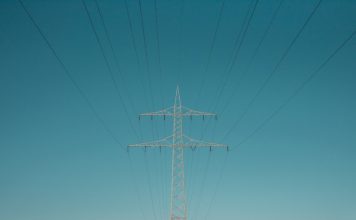 white electric post under blue sky during daytime