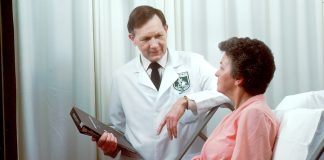 man in white button up shirt holding black tablet computer