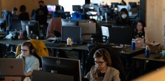a group of people working on laptops in an office