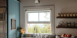 Farmhouse sink with stainless steel countertops and blue cabinets.