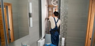 Plumber Skills That Keep Daily Water Use Stable And Stress-Free A plumber repairs plumbing in a bathroom.
