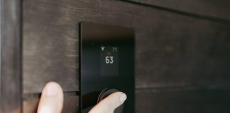 Heating Services For Homes That Expect Stable Indoor Warmth Daily Hand adjusting a digital thermostat display