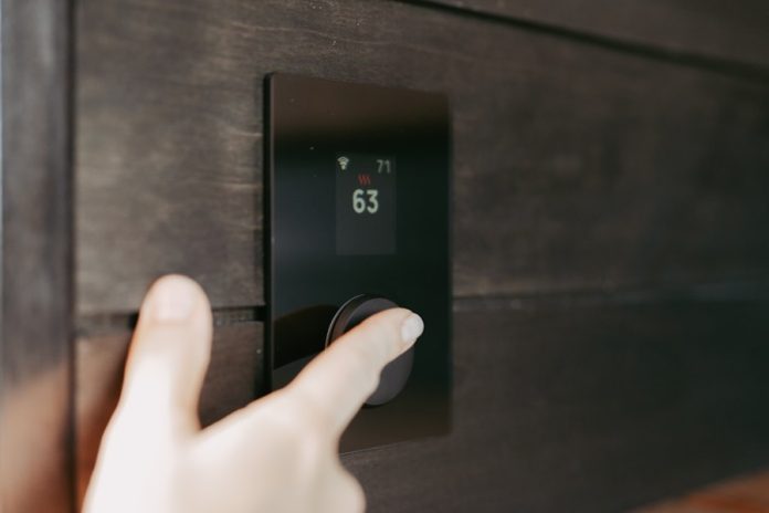 Hand adjusting a digital thermostat display