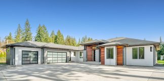 The Guide to Garage Door Maintenance for a Longer-Lasting System white and brown wooden house near green trees under blue sky during daytime
