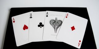 High-quality image of four aces from a deck of playing cards on a black surface.