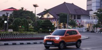 an orange truck driving down a street next to tall buildings