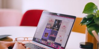 A woman sitting at a table using a laptop computer