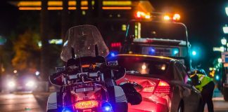 policeman leaning on sports car's window