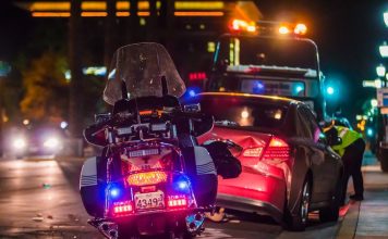 policeman leaning on sports car's window
