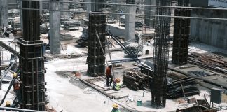 A man standing on top of a roof next to a building