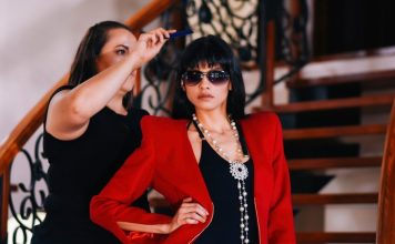 woman about to comb the hair of woman wearing red blazer