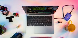 a person typing on a keyboard next to a laptop