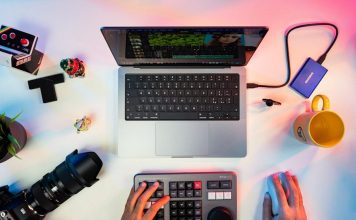 a person typing on a keyboard next to a laptop