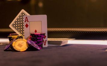 A close-up of poker chips and playing cards on a casino gaming table, highlighting Ace of Diamonds.
