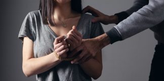 woman in gray scoop neck shirt holding her hands