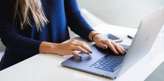 woman in blue long sleeve shirt using macbook pro