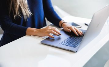 woman in blue long sleeve shirt using macbook pro