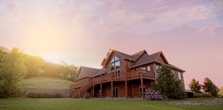 brown wooden house with green grass field