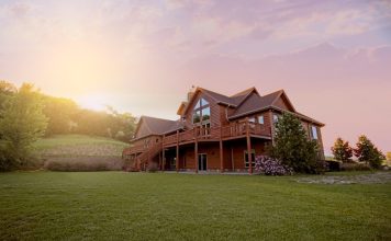 brown wooden house with green grass field