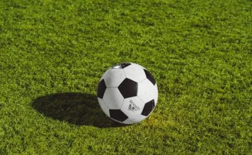 white and black soccer ball on grass field