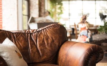 Leatherette vs Fabric Sofa: What Rising Heat Does to Each white throw pillow on brown leather armchair