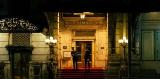 Grand building entrance with security guards on a red carpet