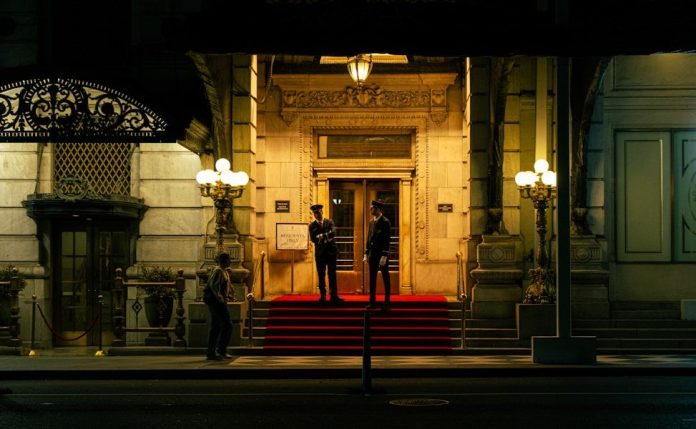 Grand building entrance with security guards on a red carpet