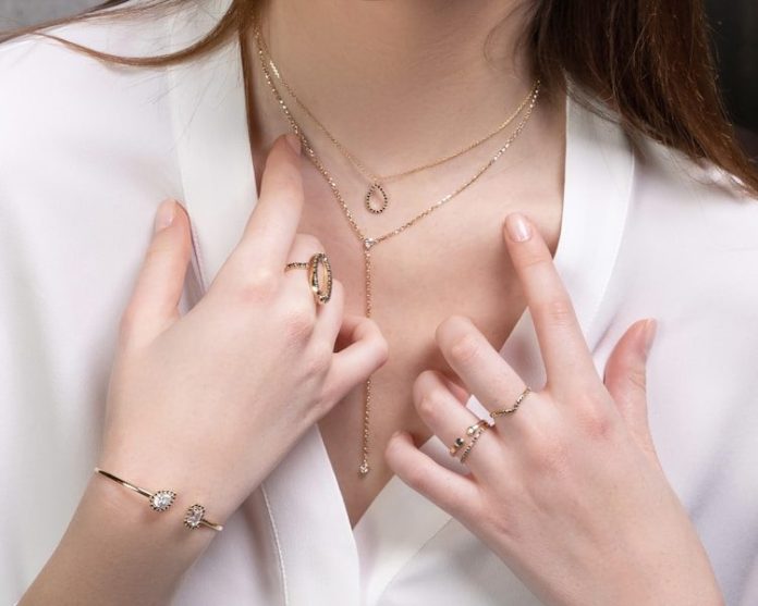 Photo by Segal Jewelry a close up of a person wearing rings and a necklace