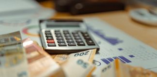 A calculator sitting on top of a pile of money