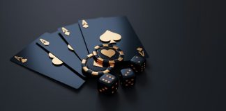 Black playing cards with gold aces, poker chips, and dice on dark surface