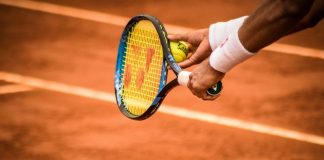 a person holding a tennis racket on a tennis court