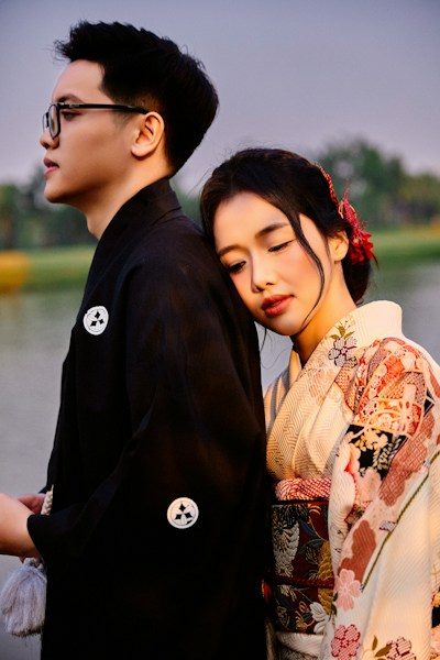 Young couple in kimonos embracing outdoors at dusk