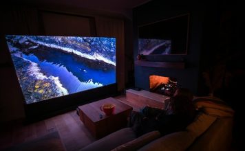 A person sitting on a couch in front of a flat screen TV