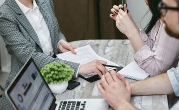 How Medical Coverage Plans Can Strengthen Your Health Security Professional meeting discussing business agreements with laptops and documents on a rustic table.