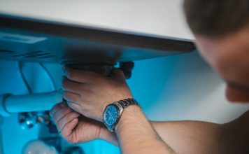 a man fixing a water heater in a room
