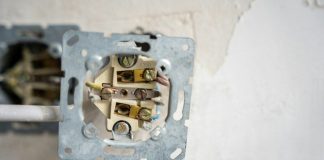 Electrical outlet disassembled, revealing the wiring